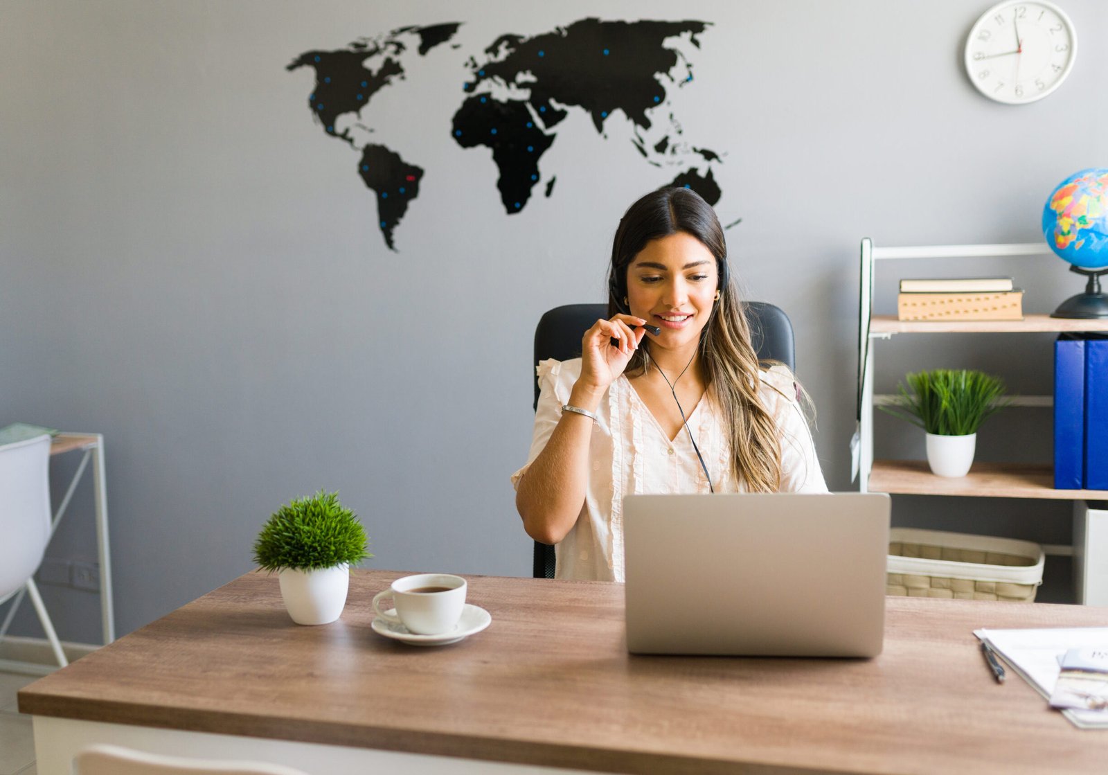Hello, how can I help you? Hispanic young woman working at a travel agency and talking with a client about booking a flight for a business trip